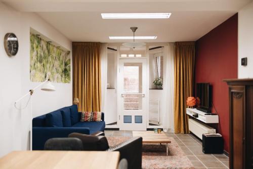 a living room with a blue couch and red walls at Independent Basement Apartment in Nijmegen