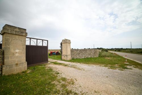 a gate and a stone wall next to a road at Agriturismo Il Poeta Contadino in Merine