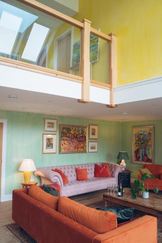 a living room with a large white couch in a room at Claggan Farmhouse, Loch Tay in Aberfeldy