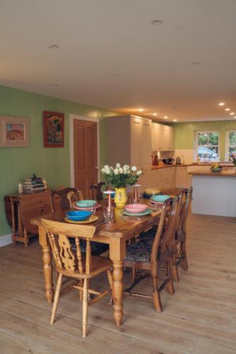 a dining room with a wooden table and chairs at Claggan Farmhouse, Loch Tay in Aberfeldy