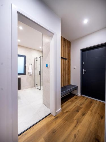 a bathroom with a shower and a black door at Wilcza Stodoła 2 in Uście