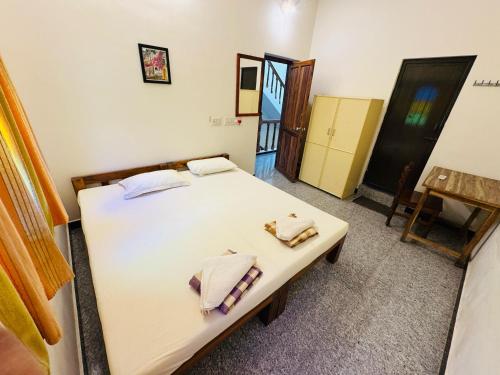 a bedroom with a bed with two towels on it at Lotus Garden Guest House in Auroville
