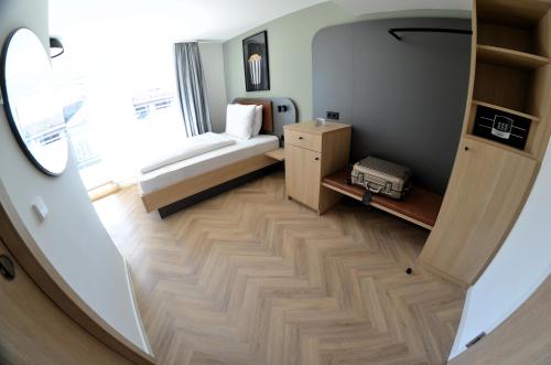 a small room with a bed and a window at Cinema City Hotel Europaplatz Karlsruhe - Brand New Boutique Hotel 2025 - in Karlsruhe