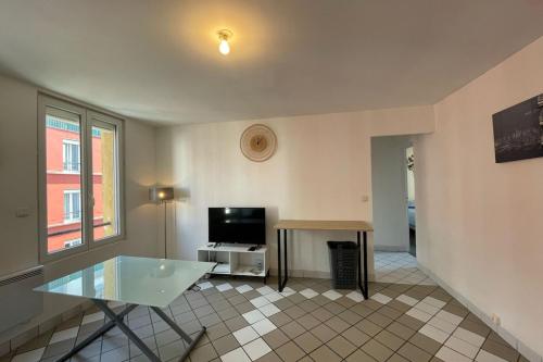 un salon avec une table et une télévision dans l'établissement Escale Baheux, au Havre