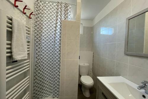 une salle de bain avec toilettes, lavabo et miroir dans l'établissement Escale Baheux, au Havre