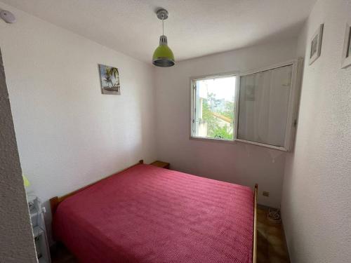 - une chambre avec un lit rose et une fenêtre dans l'établissement T2 Port St Cyprien Piscine, Clim, Parking, Animaux Ok - FR-1-106-39, à Saint-Cyprien