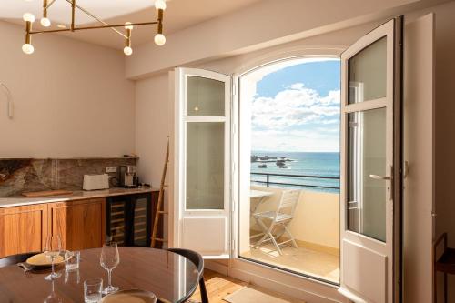 une cuisine avec une table et une vue sur l'océan dans l'établissement EUGENIE - Apt with balcony and sea view and Hotel du Palais in Biarritz, à Biarritz