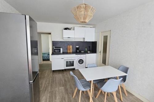 une cuisine avec une table et des chaises dans une pièce dans l'établissement Appartement spacieux F5 au Havre, au Havre