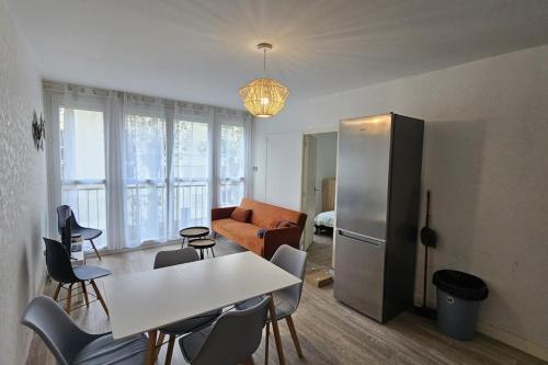 un salon avec une table et un réfrigérateur dans l'établissement Appartement spacieux F5 au Havre, au Havre