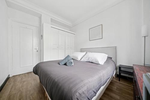 - une chambre avec un grand lit aux murs blancs dans l'établissement Magnifique appartement au cœur du 6ème, à Lyon