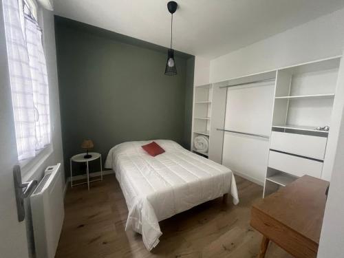 une chambre avec un lit avec un oreiller rouge dessus dans l'établissement Appartement de Ville, à Tarbes