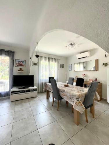 une salle à manger avec une table avec des chaises et une télévision dans l'établissement Villa GALEJADE in a quiet location with garden - On the heights of Toulon, à Toulon