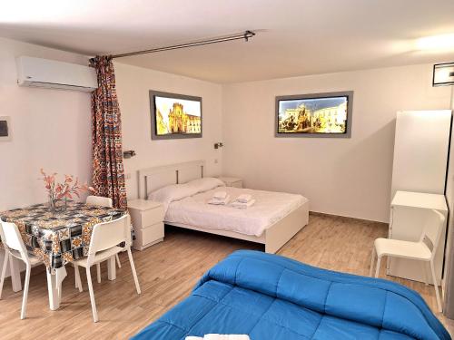 a room with two beds and a table and a dining room at Nata Sicula in Syracuse