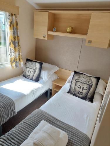 a small room with two beds with faces on them at Lotus Lodge Northumberland in Felton