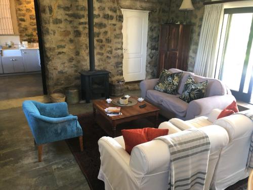 a living room with two couches and a wood stove at Springvale Farm in Nottingham Road