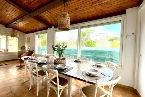une salle à manger avec une table et des chaises et une grande fenêtre dans l'établissement VILLA CONSTANCE - Swimming pool & Parking - sleeps 8, à Six-Fours-les-Plages