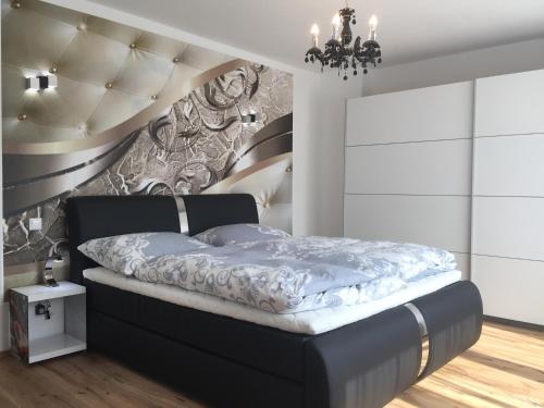 ein Schlafzimmer mit einem schwarzen Bett mit einer Wand in der Unterkunft Enjoyit-WS in Velden am Wörthersee