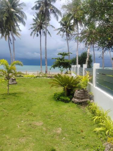 a garden with palm trees and the ocean in the background at PRIVATE VILLA FRONT BEACH Infinity Pool in San Vicente