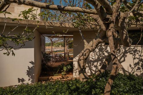 a building with a tree in the foreground at Binissaida Boutique Hotel in Es Castell