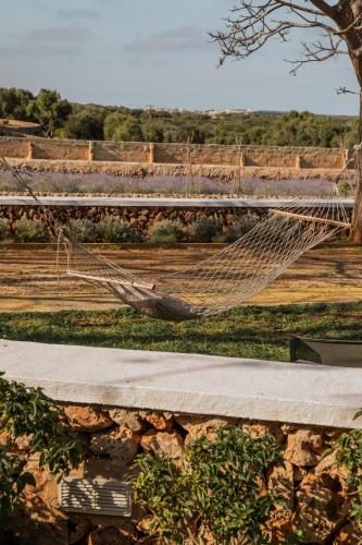 a hammock in front of a field of grapes at Binissaida Boutique Hotel in Es Castell