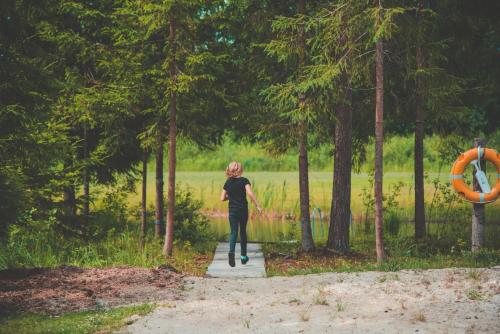 a woman walking on a path in a park at Taevaskoja Salamaa Camping in Taevaskoja