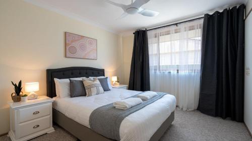 a bedroom with a large bed and a window at Coastal Crush in Callala Beach