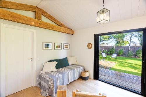 une chambre avec un lit et une grande fenêtre dans l'établissement 473 Les Landes - Coeur de la Pinède, à Saint-Clément-des-Baleines