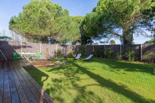 une cour avec une table, des chaises et une clôture dans l'établissement 473 Les Landes - Coeur de la Pinède, à Saint-Clément-des-Baleines