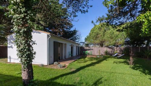 une cour avec un bâtiment blanc et une clôture dans l'établissement 473 Les Landes - Coeur de la Pinède, à Saint-Clément-des-Baleines