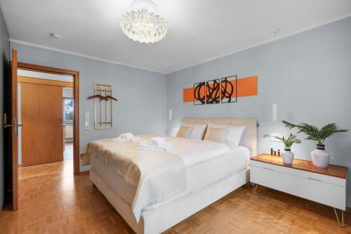 a bedroom with a large white bed and a chandelier at Elegant in Aschaffenburg