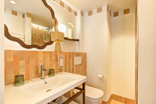 a bathroom with a sink and a toilet and a mirror at Hôtel Gabriel in Menton