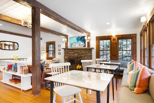 a living room with tables and chairs and a fireplace at Phoenicia Lodge in Phoenicia