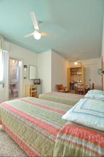 a bedroom with two beds and a living room at Hotel Residence Villa Lily in Cesenatico