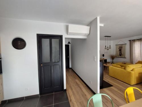 - un salon avec une porte noire et un canapé jaune dans l'établissement Bord de plage, à Bretignolles-sur-Mer