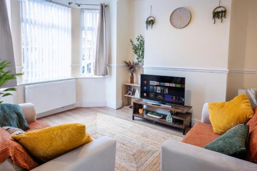 a living room with a couch and a tv at Newly Furnished Cosy 3 bed 20mins from City Center in Manchester