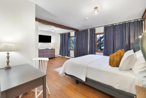 a bedroom with a bed and a desk and a television at Phoenicia Lodge in Phoenicia