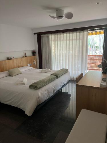 a bedroom with a large bed and a desk at Eden Mar Sant Antoni de Calonge in Sant Antoni de Calonge