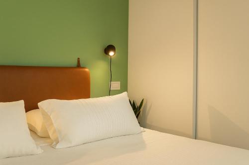 a bed with a white pillow and a lamp at Residenza 1930 in Matera