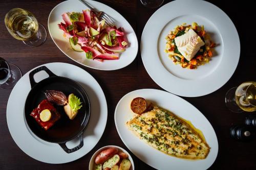 a table with white plates of food on it at Kimpton Fitzroy London by IHG in London