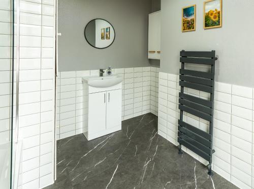 a bathroom with a sink and a mirror at Newly Furnished Cosy 3 bed 20mins from City Center in Manchester