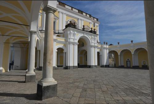 a large white building with columns in a courtyard at B&B Italia in Ercolano