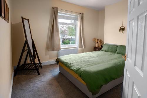 a bedroom with a bed next to a window at Newly Furnished Cosy 3 bed 20mins from City Center in Manchester