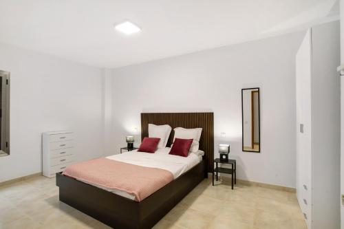 ラスパルマス・デ・グランカナリアにあるCasa Bonny Las Palmasのベッドルーム1室(大型ベッド1台、赤い枕2つ付)