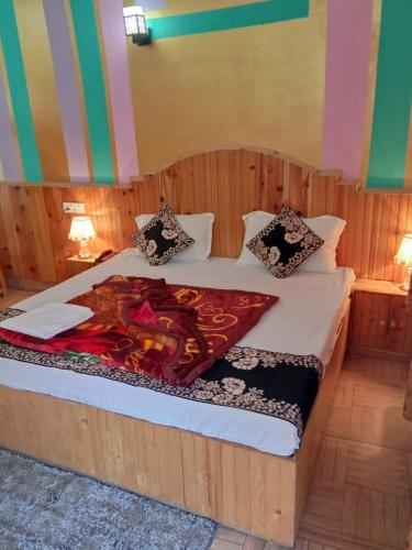Un dormitorio con una cama grande con una manta encima. en Hotel Hadimba Heights, en Manali