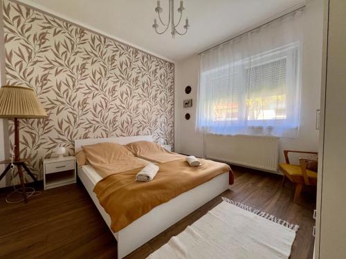 a bedroom with a bed and a wall at AranyLak vendégház in Abádszalók