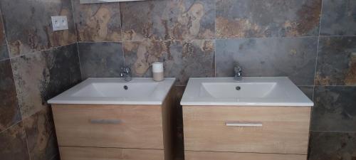 La salle de bains est pourvue d'un lavabo blanc et de placards en bois. dans l'établissement Fior di Lucia, à Zonza