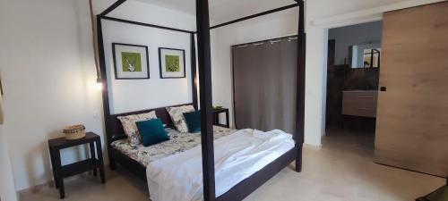 - une chambre avec un lit à baldaquin et des oreillers bleus dans l'établissement Fior di Lucia, à Zonza