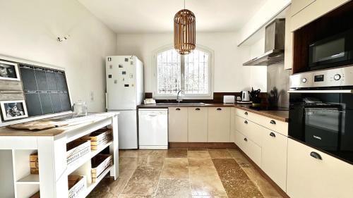 une cuisine avec des armoires blanches et un réfrigérateur blanc dans l'établissement Maison Campagne Aixoise, à Ventabren