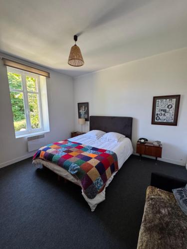 a bedroom with a bed with a colorful blanket at Cottage-Saint Laurent sur Sèvre in Saint-Laurent-sur-Sèvre
