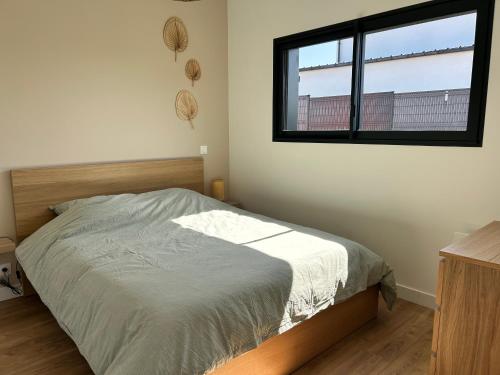 a bedroom with a bed and a window at Maison Bâbord, Près des plages et du centre GR34 WIFI in Trégastel